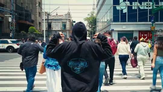A hooded Wodapalooza figure among a Mexico City crowd